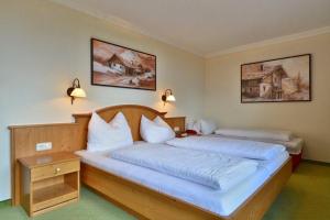 延巴赫Gasthof und Hotel Rieder GmbH的一间卧室配有两张带白色枕头的床