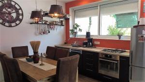 格拉达茨Apartman Rustico的厨房配有木桌和冰箱。