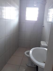 瓜鲁柳斯Hotel tenda 1的白色的浴室设有卫生间和水槽。