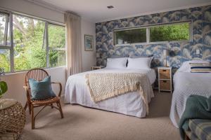 EskdaleSeahurst Apartment的蓝色和白色的卧室配有两张床和椅子