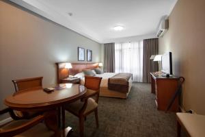 圣米格尔·德·图库玛图库曼中心商务套房酒店的酒店客房配有一张床铺和一张桌子。
