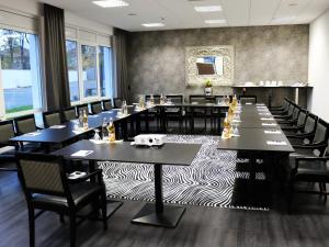 埃尔维特Kurhaus Design Boutique Hotel的大型用餐室配有桌椅