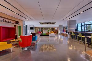 海法Haifa Bay View Hotel By AFI Hotels的大堂,大楼里摆放着五颜六色的桌椅