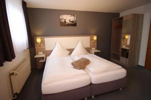布伦瑞克艾格霍夫酒店餐厅的卧室配有白色大床和白色枕头