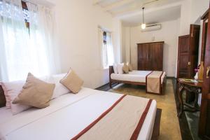阿杭格默Villa Indrasiriya的客厅配有白色的沙发和床。