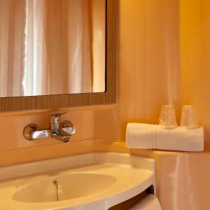 佩皮尼昂南佩尼皮昂普瑞米尔经典酒店的浴室配有盥洗盆、镜子和毛巾