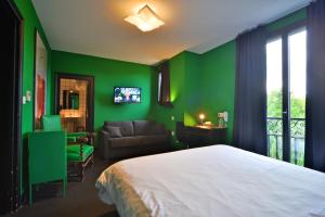 维耶尔宗Logis - Hotel Restaurant La Mire的绿色卧室配有床和沙发