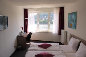 雷马根APTE莱茵酒店的酒店客房设有两张床、一张书桌和一个窗户。