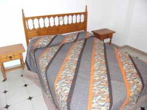 莱斯卡拉Casa la Flor的一间卧室配有一张带两张木桌的床
