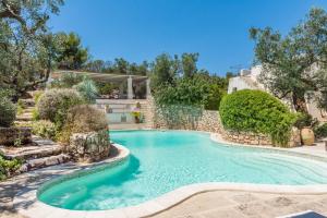 拉卡莱Tenuta Aphrodite的一座树木繁茂的庭院内的游泳池