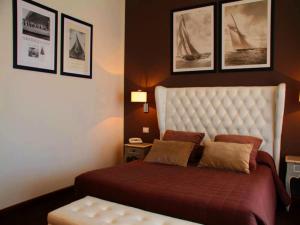 拉瓦尼亚安科拉海滨酒店的卧室配有一张大床,墙上挂有图片