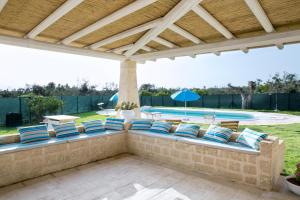 托雷苏达Villa Trullo Indipendente的一个带蓝色和白色枕头的庭院和一个游泳池