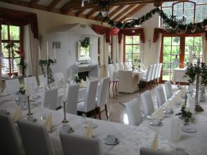 HelmbrechtsGasthof Bischofsmühle的用餐室配有白色的桌子和白色的椅子
