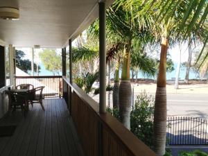赫维湾海湾椰树酒店的棕榈树的门廊和桌子
