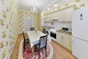 阿斯塔纳Apartments LUX 53/144的厨房配有桌子和冰箱