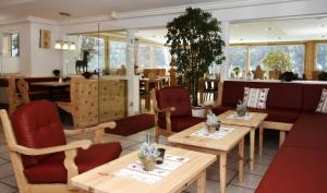 施库尔加尼全景酒店的餐厅设有木桌和红色椅子