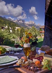 莫埃纳坎缇娜希翁玫瑰园酒店的一张桌子上放着一杯葡萄酒和食物