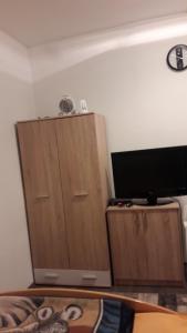 巴尼亚卢卡Rooms Adrijana的客房设有2个木制橱柜和1台平面电视。