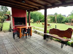 洛斯雷特斯Ensueño Cabañas的庭院设有桌子、壁炉和长凳。