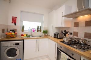 QueensburyAmbler Thorn Lodge的厨房配有白色橱柜和洗衣机。