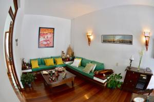 萨尔瓦多Pousada Baluarte的客厅配有绿色沙发和桌子