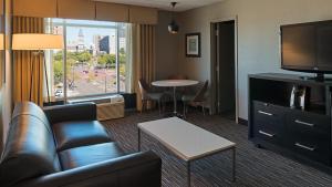 圣保罗Holiday Inn St. Paul Downtown, an IHG Hotel的带沙发、电视和桌子的客厅