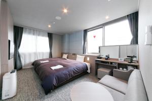 名古屋名古屋新干线口酒店的一间卧室配有一张床、一张桌子和一张沙发