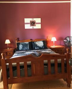 金斯科特Armadale House - Kingscote的一间卧室配有一张木床和两盏灯。