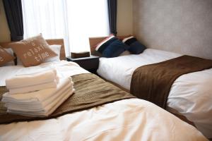 长崎安比亚拉多扎公寓的两张睡床彼此相邻,位于一个房间里
