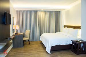卡兰巴马西亚诺酒店的酒店客房配有一张床、一张书桌和一台电视。
