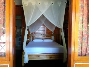 布纳肯Raja Laut Dive Resort Bunaken的一间卧室配有一张带天蓬的床