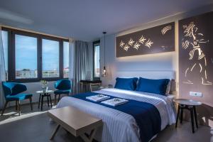 海若克利欧Lavris City Suites的酒店客房带一张床、一张桌子和椅子
