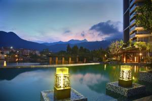 深圳深圳大梅沙京基海湾大酒店的酒店游泳池的背景是山脉