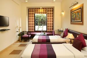 古尔冈Ahuja Residency Parklane, Gurgaon的一间酒店客房,设有两张床和电视