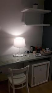 韦尔纳扎Santa Marta Rooms - Via Roma 23的椅子上桌子上的一盏灯