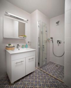 海法Diana Hotel的浴室配有白色水槽和淋浴。