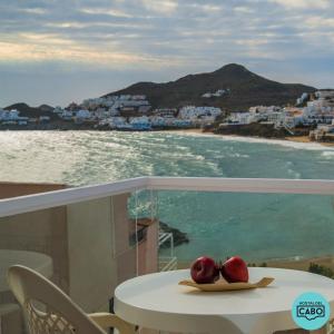 圣何塞Hostal del Cabo的桌子上盘子上的两颗苹果,享有海景
