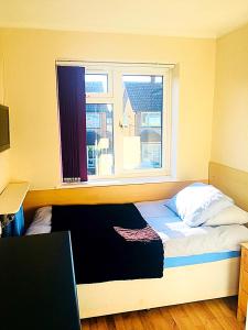 切森特希瑟小屋旅馆的一间卧室配有一张带窗户的床和一张书桌