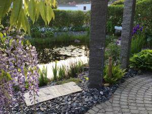 佩瑞BnB Villa Levanta的花园,花园内有池塘,树木和鲜花