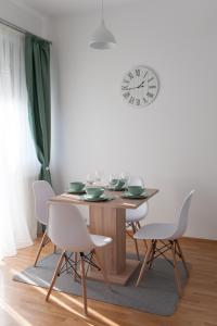 贝尔格莱德Apartment Ada的餐桌、椅子和墙上的时钟