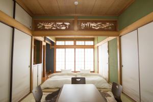 松山道后宿度假屋的卧室配有一张床和一张桌子及椅子