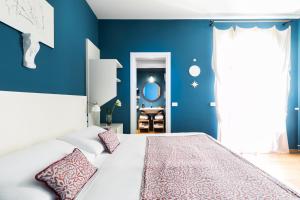 罗马稀世套房旅馆的一间卧室拥有蓝色的墙壁,配有一张带枕头的床。
