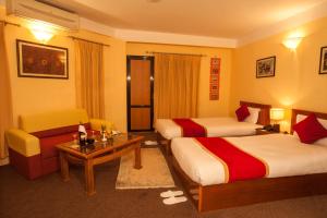 加德满都皇家阿斯托里亚酒店的酒店客房,设有两张床和一张沙发