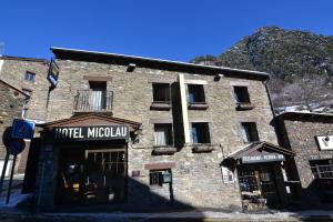 阿林萨尔Hotel Micolau的一座古老的石头建筑,前面有酒店