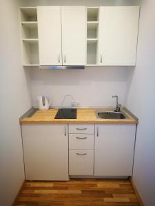 卡尔克尔Klevas的厨房配有白色橱柜和水槽