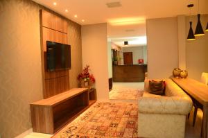 卡塔洛Hotel Flamboyant的带沙发和平面电视的客厅