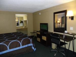 兰塔纳兰坦纳西棕榈滩速8酒店的酒店客房配有一张床、一张书桌和一台电视。
