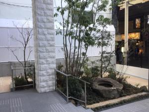 大阪Bande Hotel Osaka的建筑物前有树的建筑物