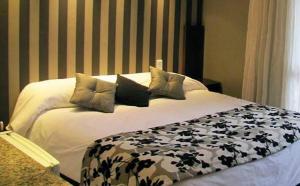 塞拉德洛斯帕德雷斯Hotel Sierra de los Padres的一张配有黑白床单和枕头的床