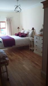 利默里克Hazel Cottage的一间卧室配有一张大床和一个梳妆台